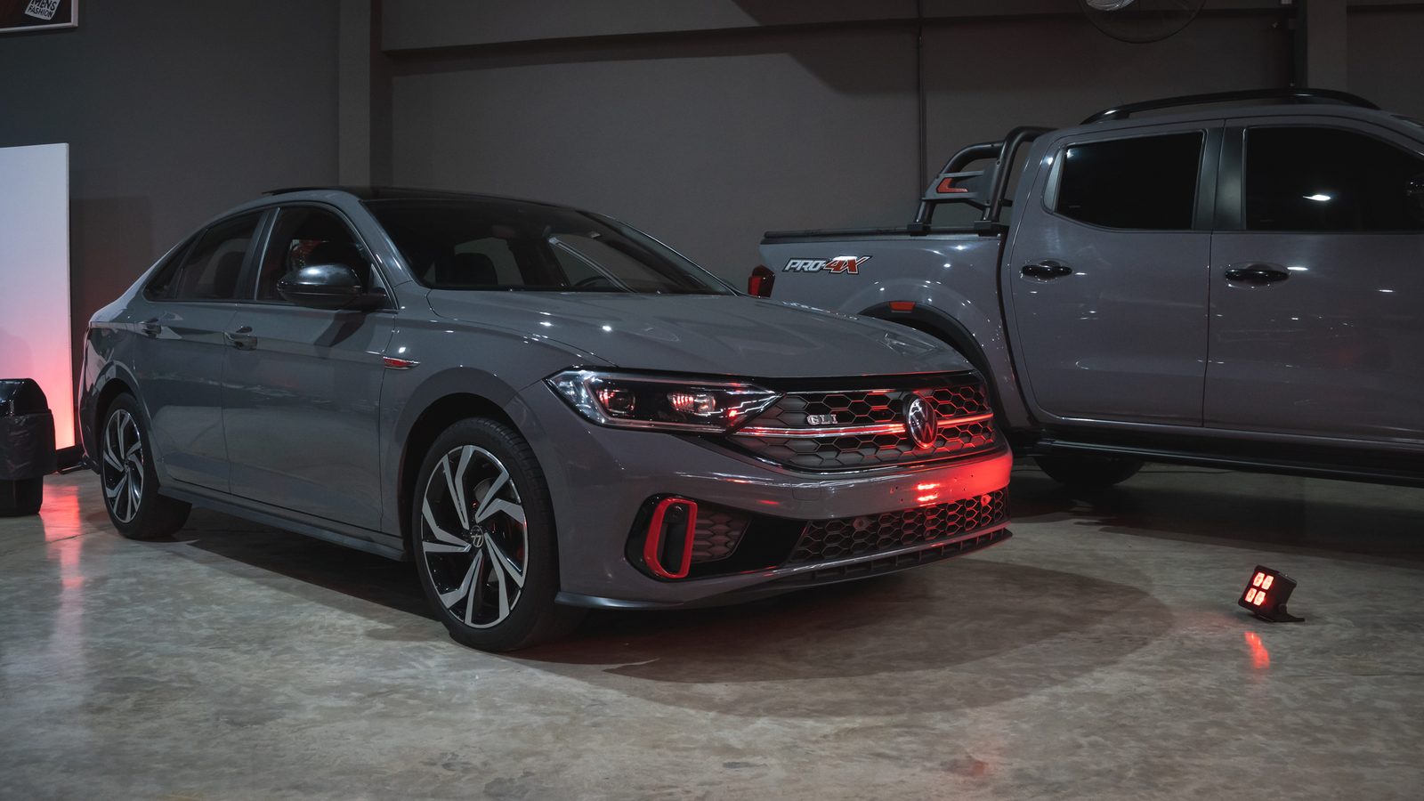 Volkswagen Polo GLI gris iluminado con luces rojas en el salón F27 durante la inauguración