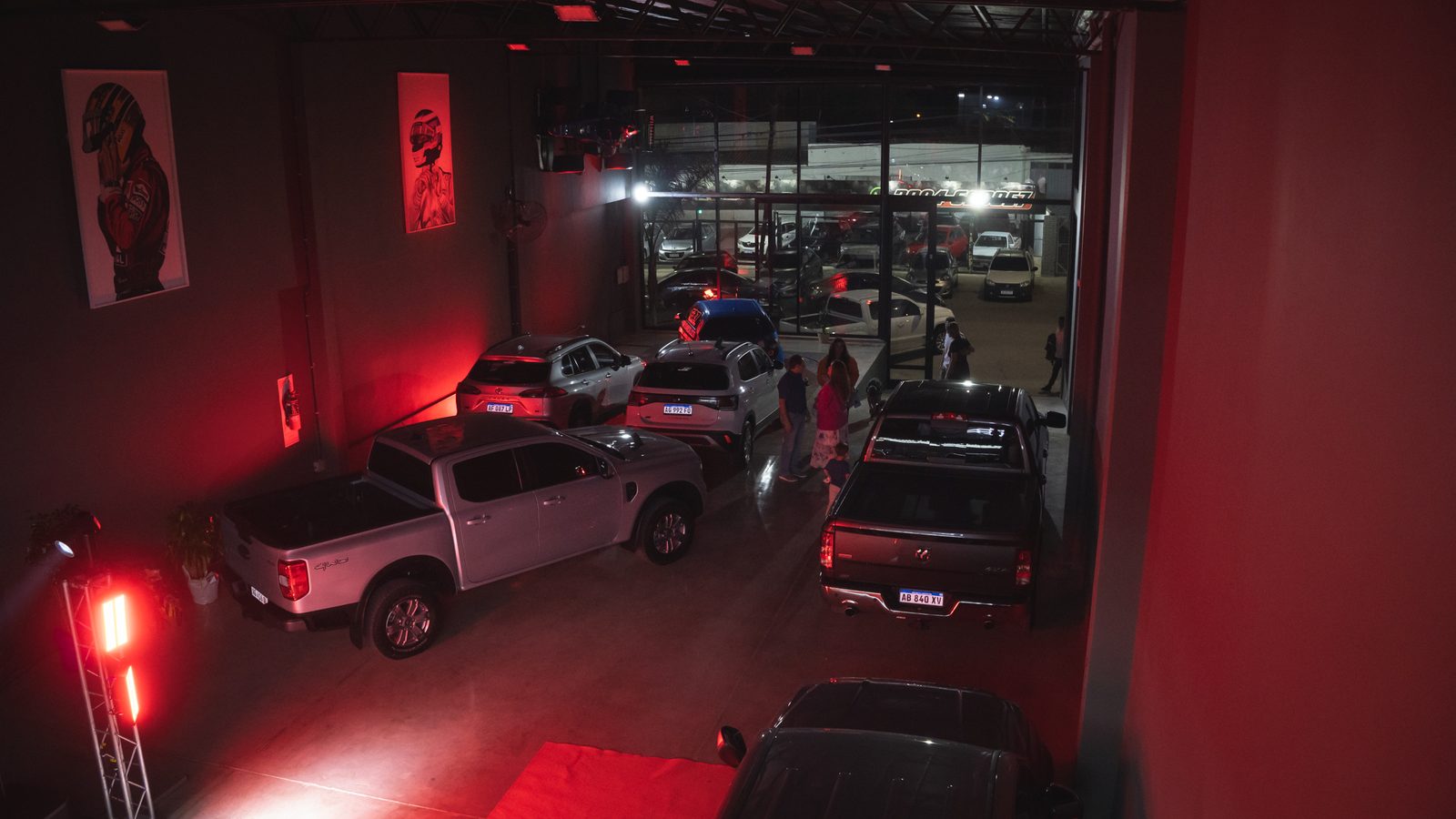 Vista aérea del salón F27 en la noche de inauguración, pickups y público bajo luces rojas