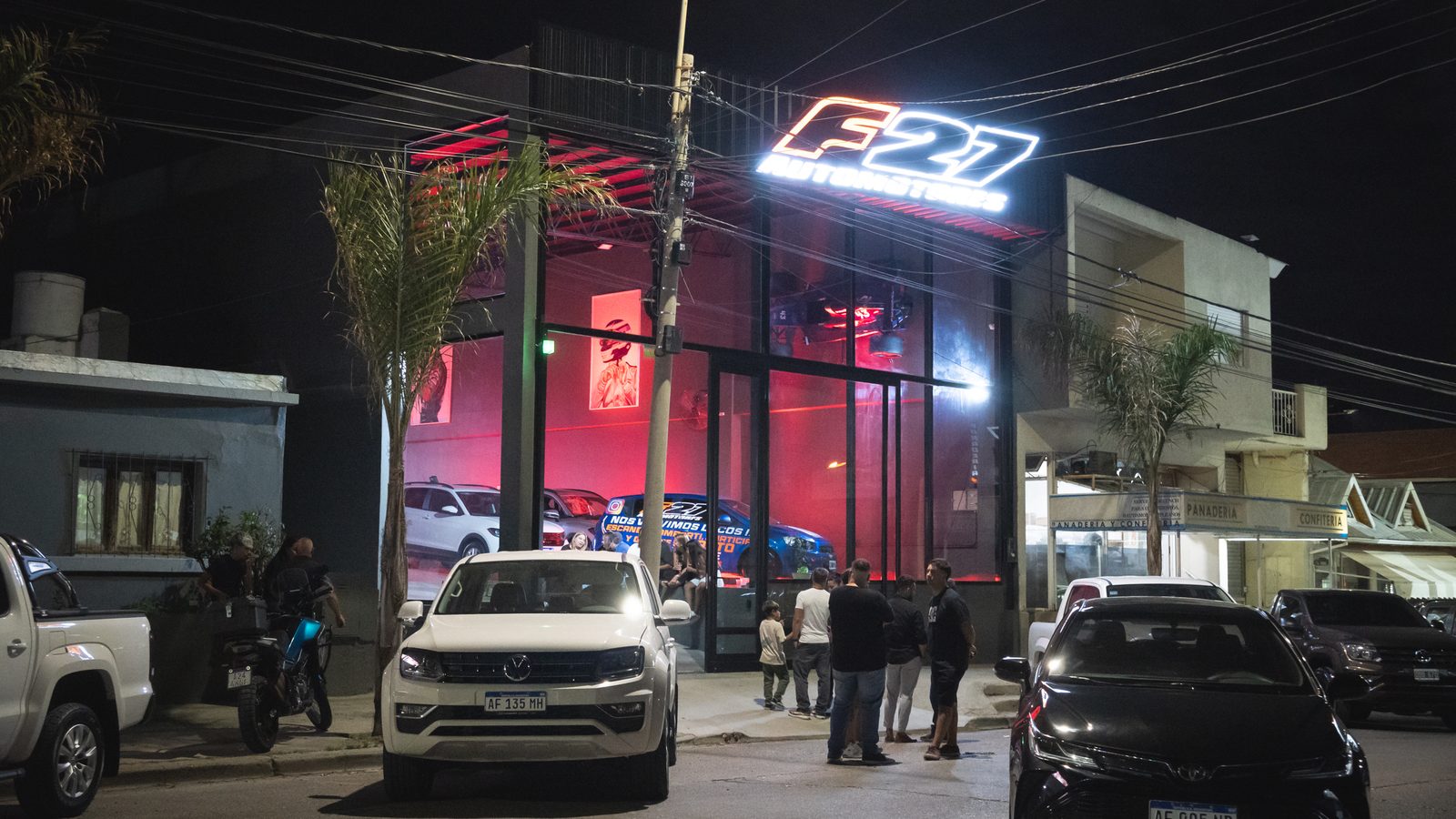 Fachada nocturna del local F27 Automotores en Puerto Madryn con cartel luminoso rojo