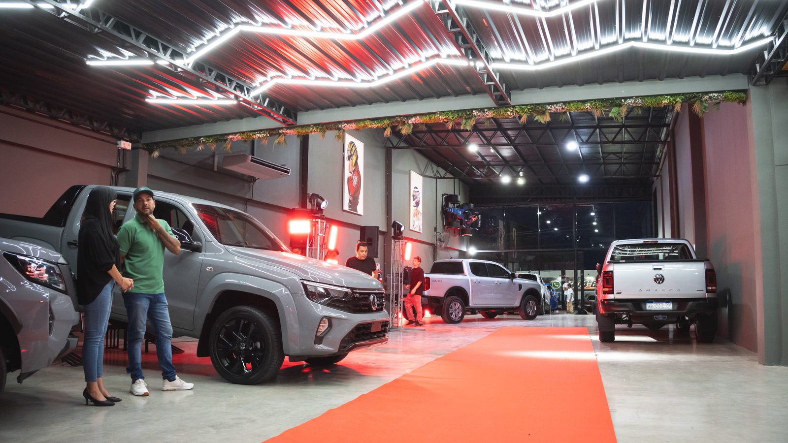 Pareja mirando una Hilux plateada en el salón F27 durante el evento de inauguración